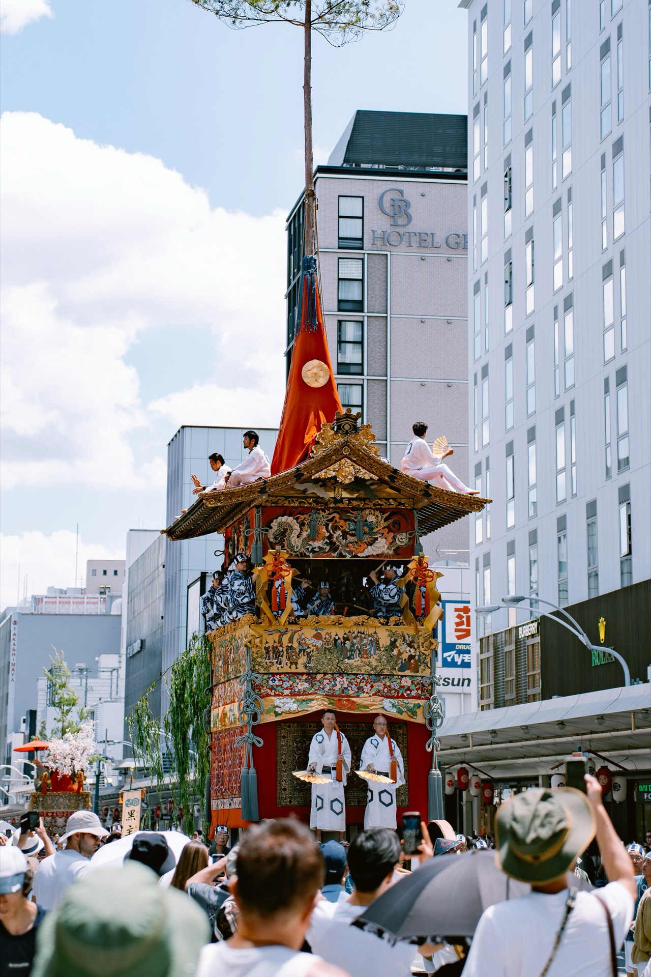 Festival float in a city street with performers and a crowd